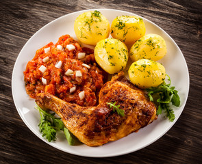Barbecued chicken legs with boiled potatoes and vegetables