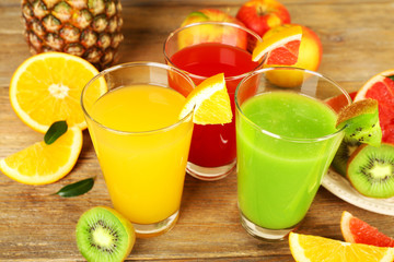Fresh juices with fruits on wooden table