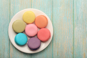 Fototapeta na wymiar Tasty colorful macaroons in small plate