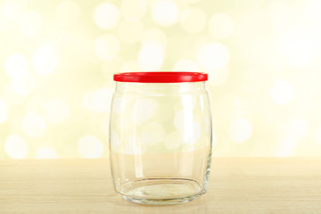 Empty glass bottle on table on bright background