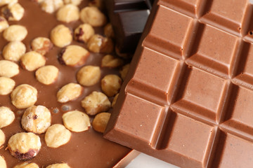 Black and milk chocolate bars with hazelnuts close up