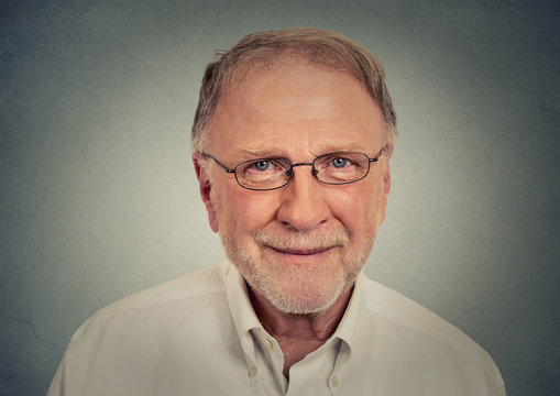 Portrait of happy Old Man with glasses on gray background 