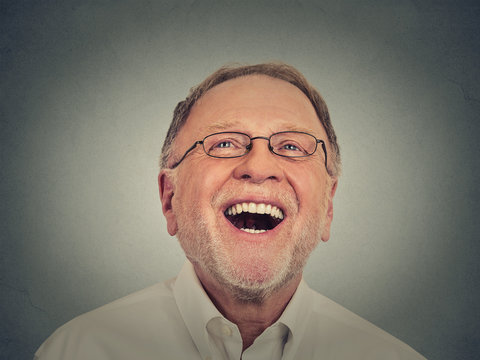 Laughing senior man isolated on gray background 