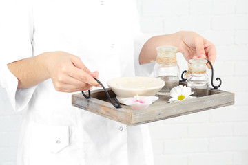 Beauty therapist holding tray of spa treatments, close-up