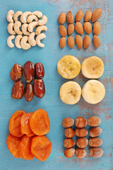 Dried fruits and nuts on color wooden background