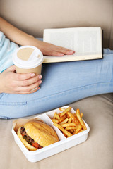 Woman with unhealthy fast food, close-up