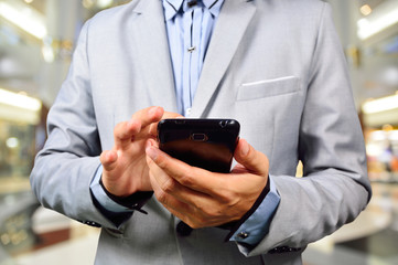 Handsome young man in shopping mall using mobile tablet