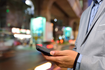 Handsome man using smart phone mobile in the city at night