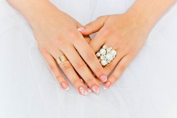 Gemstone ring with pearls on the fingers of the bride