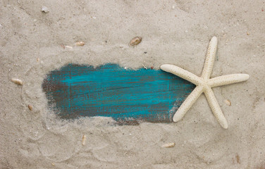 Fototapeta na wymiar Blank teal blue sign surrounded by beach and starfish