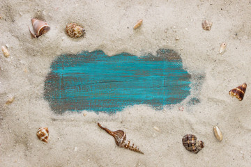 Fototapeta na wymiar Blank teal blue sign surrounded by beach and seashells