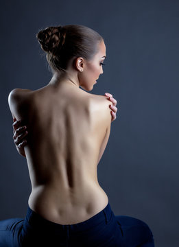 Rear view of slim model posing with naked back