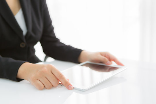 Woman hand touch white tablet with blank empty screen