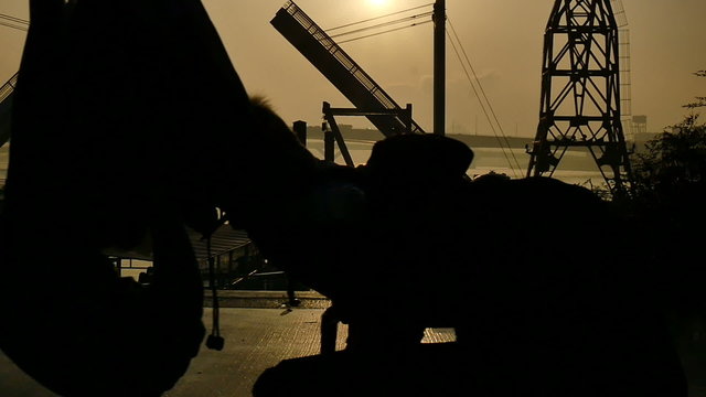 Slow motion sunset silhouette of people on the boardwalk.
