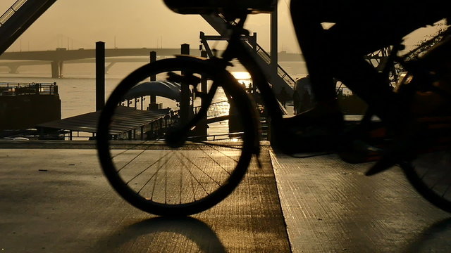Slow motion sunset silhouette of people on the boardwalk.