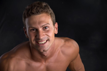 Fototapeta premium Head and shoulder shot of shirtless handsome young man smiling