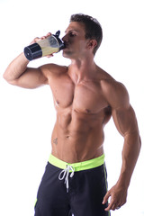 Muscular shirtless male bodybuilder holding protein shake bottle