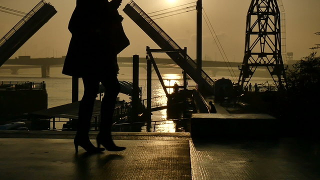 Slow motion sunset silhouette of people on the boardwalk.