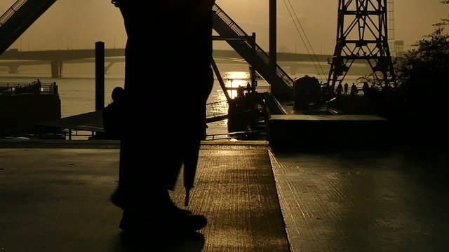 Slow motion sunset silhouette of people on the boardwalk.