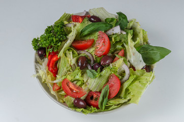 Bowl of salad with fresh vegetables on white backgroound