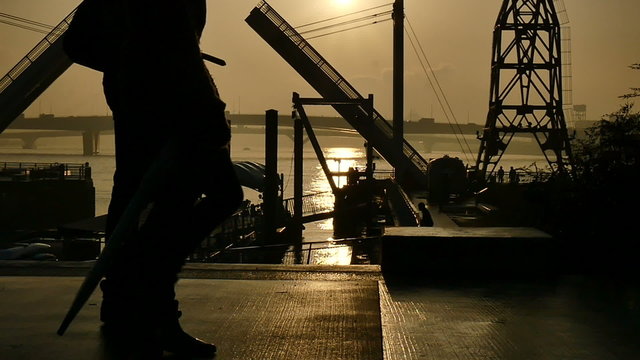 Slow motion sunset silhouette of people on the boardwalk.