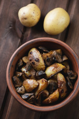 Ceramic bowl with roasted potato and mushrooms, above view