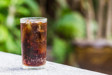 Glass of cola with ice cubes .