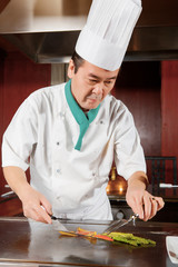 Cook puts vegetables to the dish