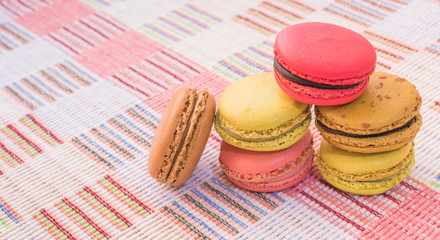 Sweet and colourful french macaroons on cotton cloth background.