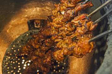 Chicken kebabs cooking in a tandoori oven