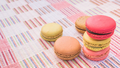 Sweet and colourful french macaroons on cotton cloth background.