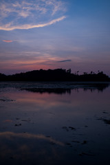 Fototapeta premium the beach with reflection in water during sunset.