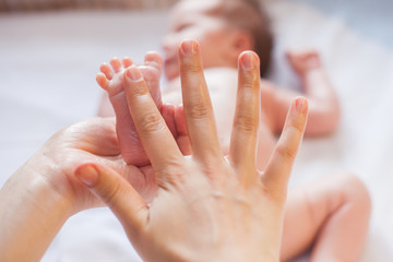 Mother makes massage for happy baby