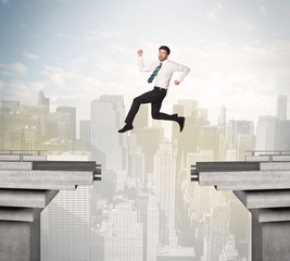 Energetic business man jumping over a bridge with gap