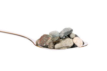 Concept about hard digestion. Spoon with stones