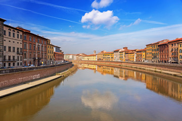 Old town of Pisa with reflection in Arno river, Italy