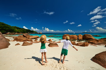 Fototapeta na wymiar Couple in green having fun on a beach at Seychelles