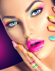 Beauty girl face with vivid makeup and colorful nail polish