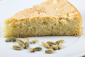 a piece of spongecake and cardamom seeds on a plate