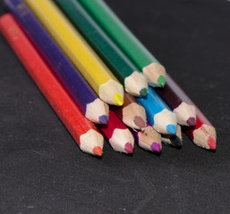 many bright colored pencils close-up on black background