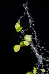 Limes with water splashes on black background