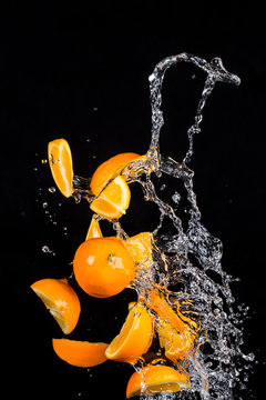 Oranges with water splashes on black background