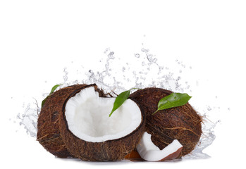 Cracked coconuts in water splash on white