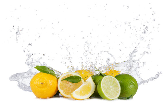Lemons and limes with water splashes on white