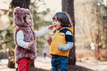 happy toddler friends sharing cookies on the walk
