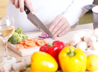 Obraz na płótnie Canvas Close up of female hands cutting vegetables.