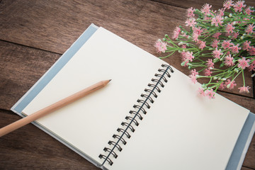 Pencil with book on wooden table