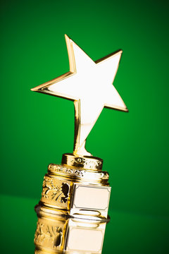 gold star trophy against green background