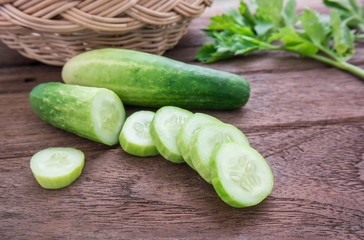 Fresh cucumber and slices on wooden table