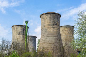 Power plant towers in spring green landscape and blue sky